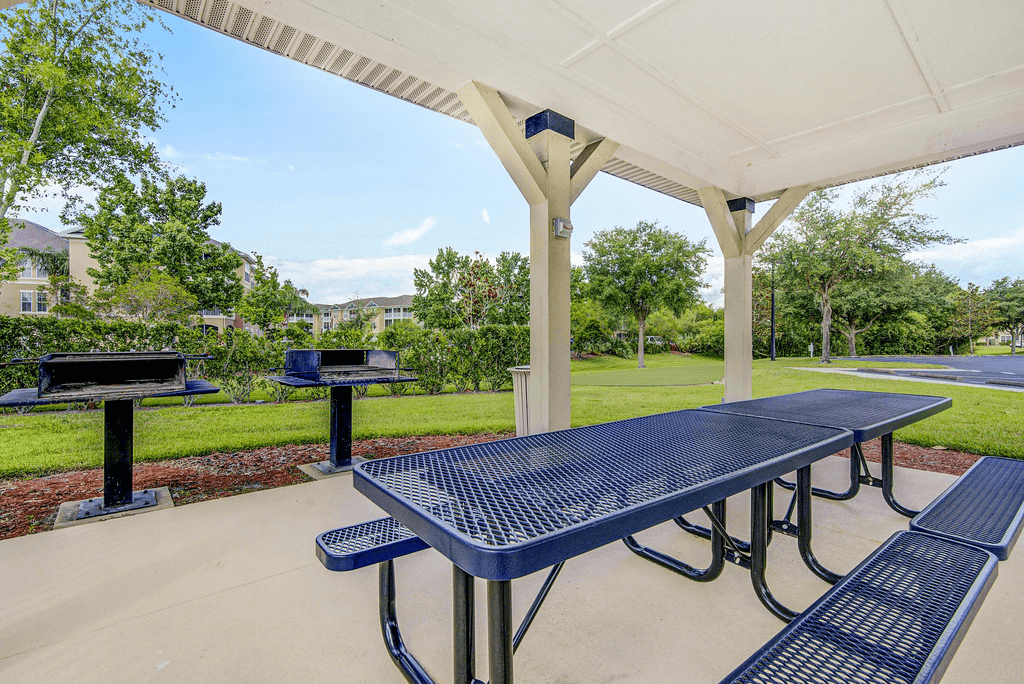 Covered grill area with picnic tables and native landscape in background